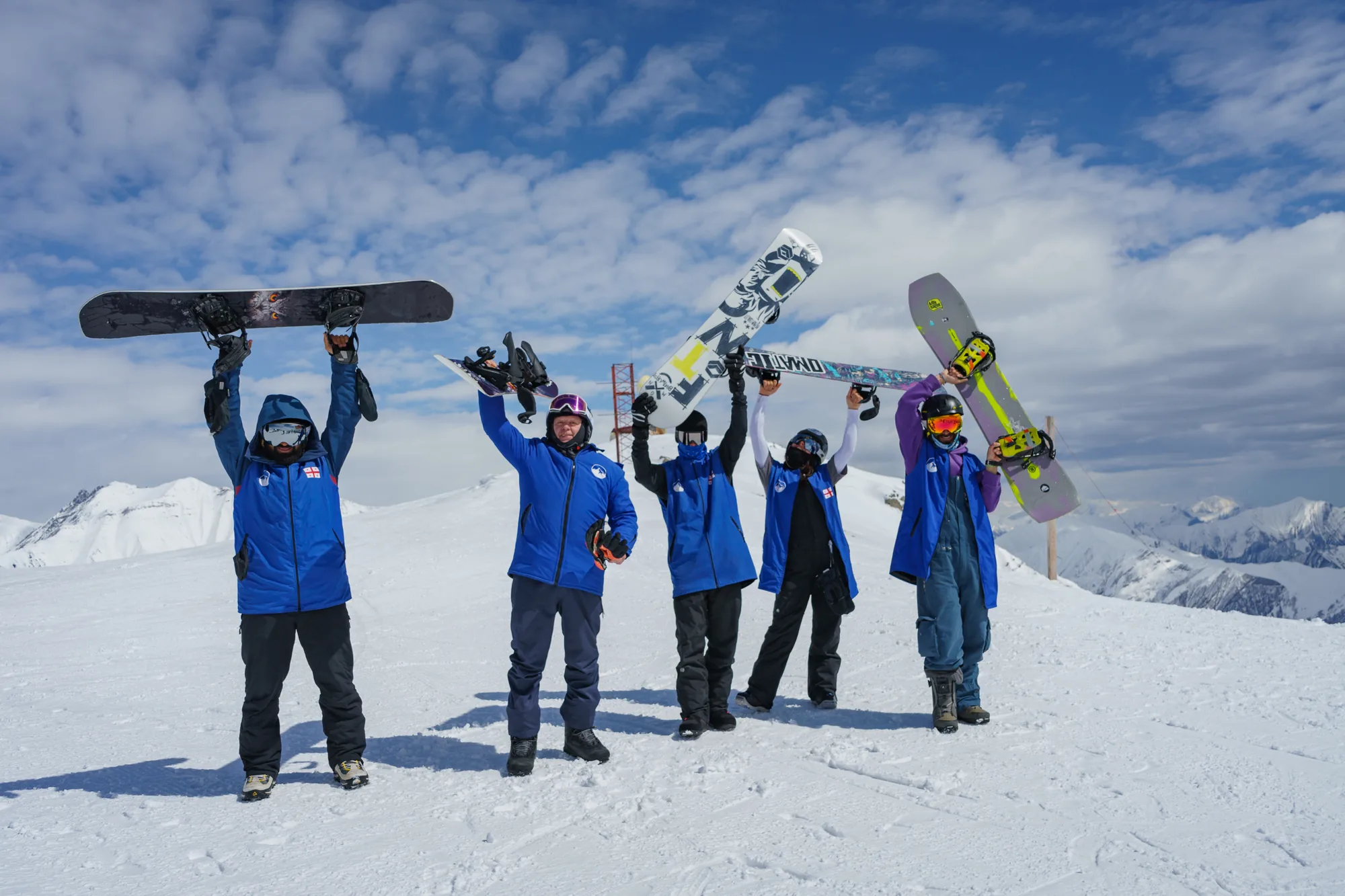 Gudauri 2000 instructors and students holding their boards up on the ridge above Gudauri